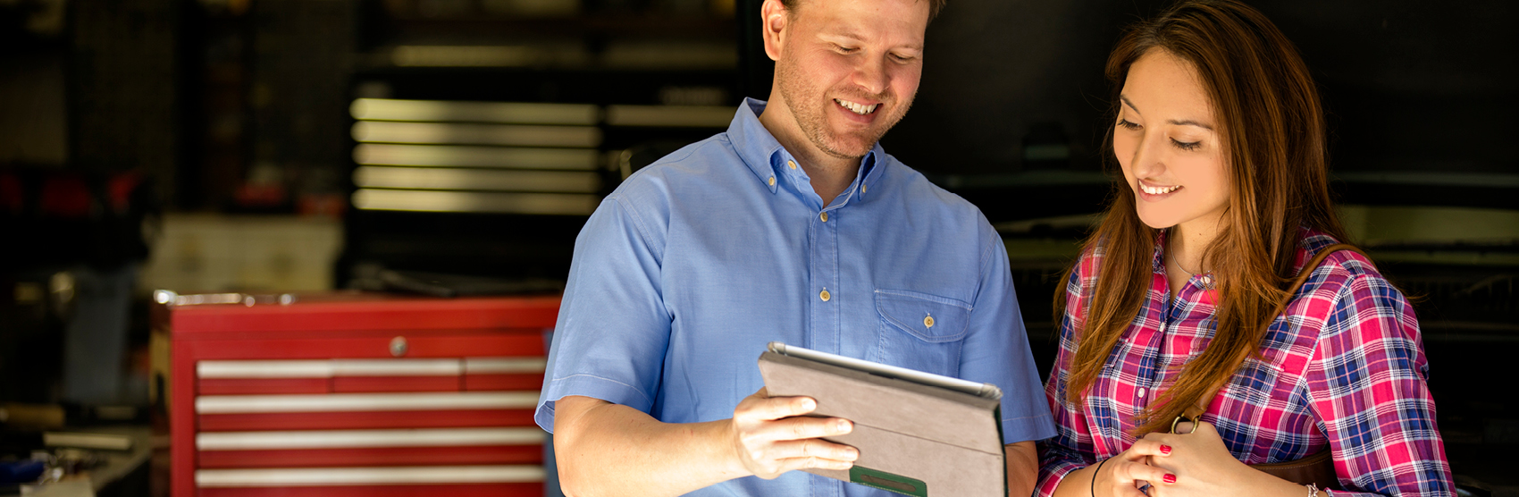 Auto mechanic talking about bill with woman