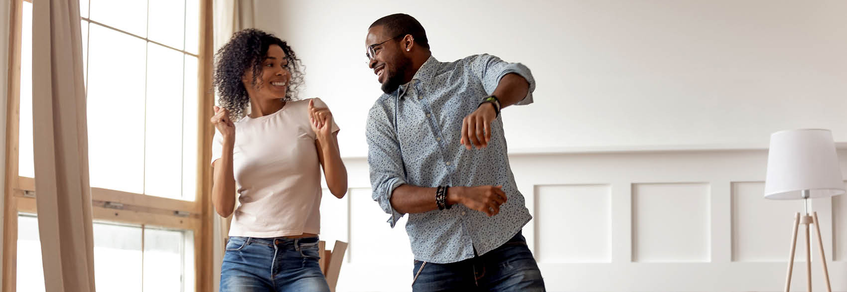 Two happy people dancing at home